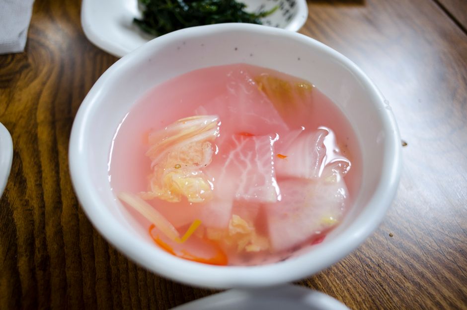 Nabak kimchi Korean water kimchi fermenting in a glass jar