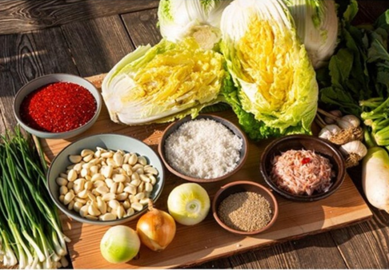 Ready-made kimchi seasoning paste being mixed with salted napa cabbage for homemade kimchi