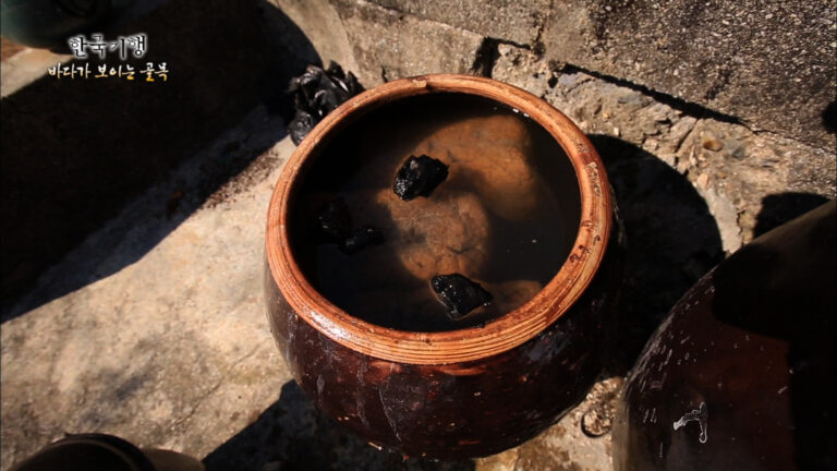 Traditional Korean soy sauce ganjang aging in onggi pots with fermented meju soybean blocks